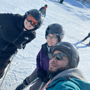 Geoffrey, Sheila and Kaylie posing for a picture with their winter gear on while skiing on Buckhill